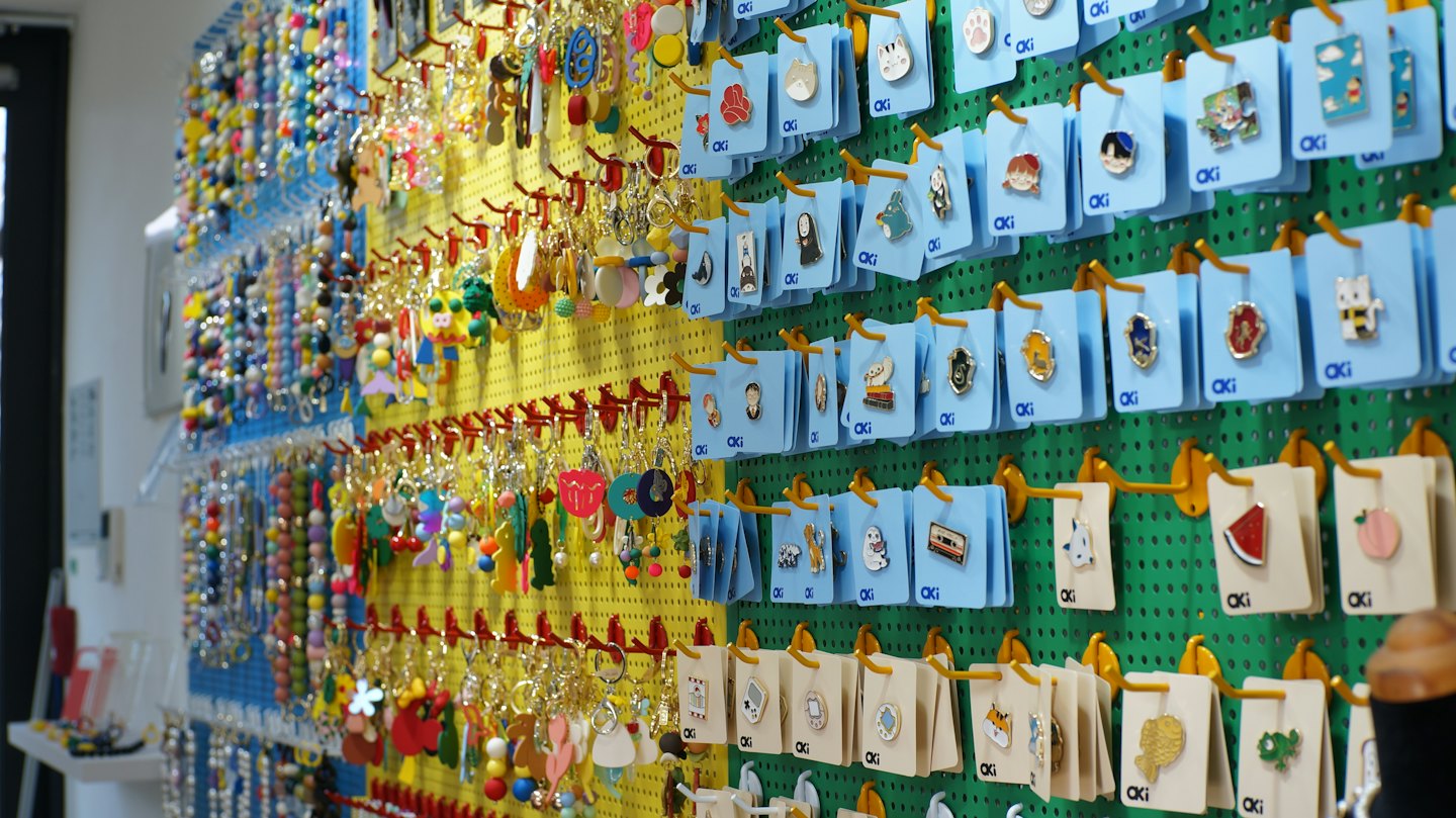 Pegboard-Wand mit vielen bunten Schlüsselanhängern und Ansteckern.